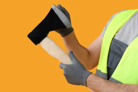 Male worker with sharp ax on yellow background, closeup Stock Photos
