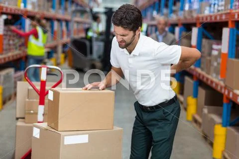 Male worker suffering from back pain while working Stock Photos