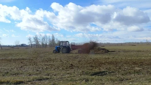 Male worker on tractor with trailer going around field Stock Footage 75434527