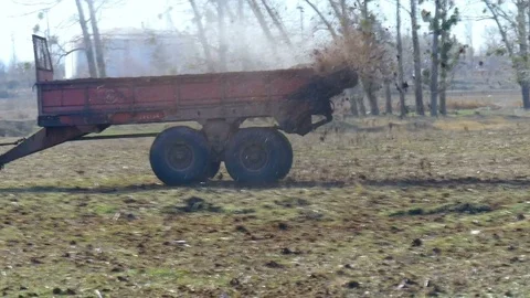 Male worker on tractor with trailer going around field Stock Footage 75435738