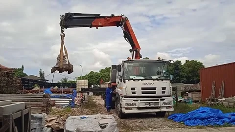 Male Worker Unloading Material Using Crane Truck and Moving Clouds Stock Footage 305771494