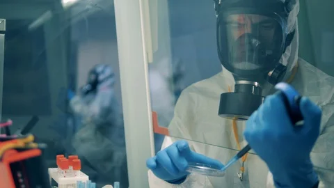 Male worker uses pipette while developing a vaccine in laboratory. Video stock 129521321