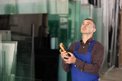 Male worker using control panel and lifting mechanism controls movement of Stock Photos