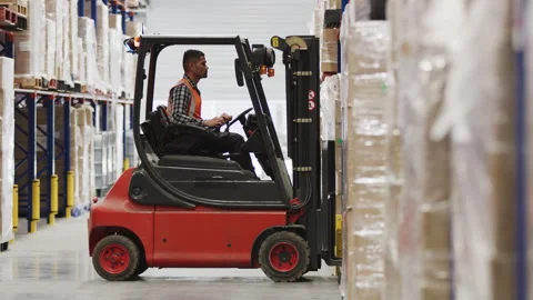 A male worker in the warehouse using a forklift to move products Stock Footage 264083193