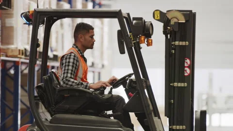 A male worker in the warehouse using a forklift Stock Footage 264083280