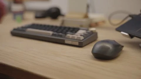 Male worker's hand using a computer mouse on a wooden desk with a keyboard 스톡 동영상 335206615