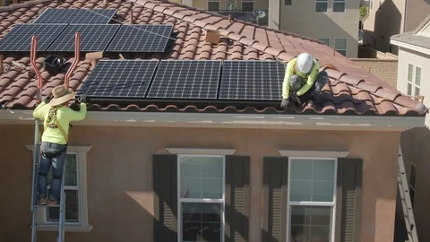 Male workers installing solar panels on residential tiled home rooftop. Video stock 115128138