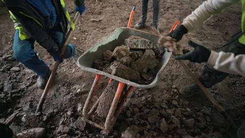 Male workers stack pieces of concrete floor into a wheelbarrow Stock Footage 264421952