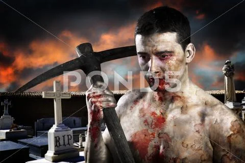 Male zombie in a cemetery, undertaker with pick axe Stock Photos