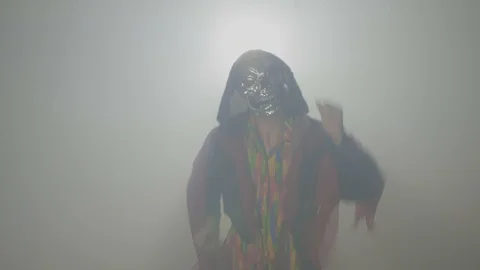 Malefic evil creature wearing a mask and doing the funny zombie dance in fog  Stock Footage 86564323
