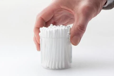 Male's hand taking a permanent box with many white cotton buds Stock Photos