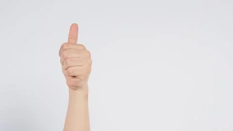 Male's left hand doing thumbs up sign on white background. Stock Photos