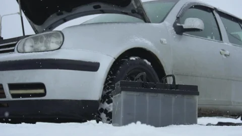 Malfunction or problem with broken car in winter snowfall. Automotive battery Stock Footage 120831545