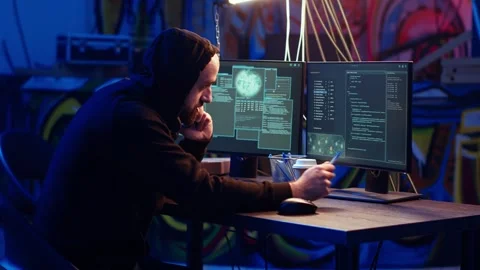 Malicious man hacking and talking on phone with partner Video stock 319551556