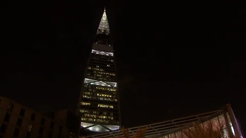 A mall with the Faisaliah Tower in the background and cars passing in the Stock Footage 120059068