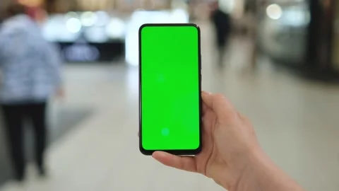 Mall. Shopping center. Back view of brunette holding chroma key green screen sma Video stock 156228734