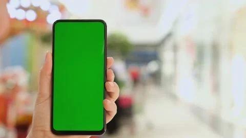 Mall. Shopping center. Back view of brunette holding chroma key green screen sma Stock Footage 156229569