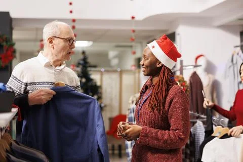 Mall worker showing clothes to client 写真素材