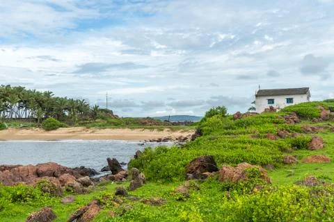 Malvan beach with church and blue sky green mountain in front Stock Photos