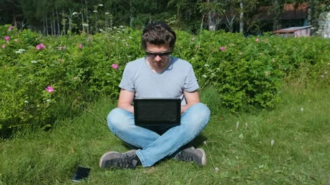 Mam is working typing on laptop sitting in Park in summer. Stock Footage 102450876