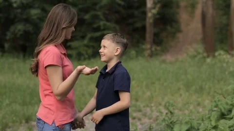 Mama gently hugs her son in the park Stock Footage 76166178