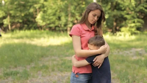 Mama gently hugs her son in the park Vidéo 76166333