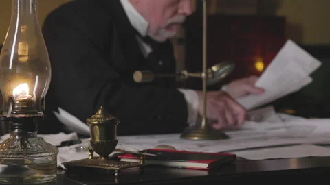 Man in the 1800s using free standing magnifying glass focus on oil lamp Stock Footage 336746722