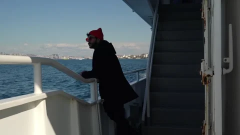 A man of 20-30 years old stands on the lower deck of ferry and looks to the sea Stock Footage 240533296