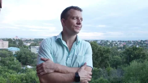 A man of 30-40 years old folded his arms on his chest and looks alternately t Stock Footage 201841838