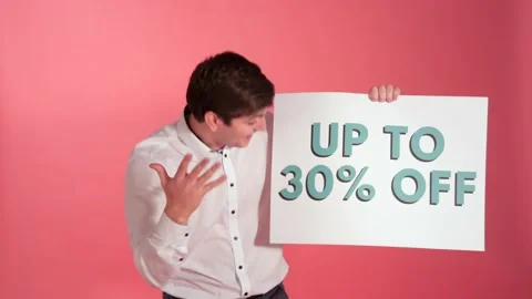Man With 30% Off Sign Invites Shopper As Looking Into Camera, Studio Shot Stock Footage