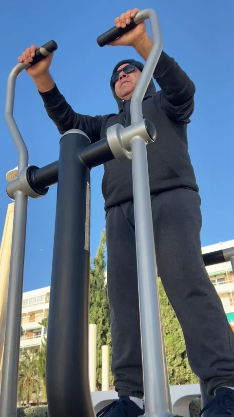 Man 50+ exercising on step machine with low-angle shot Stock Footage 328363886