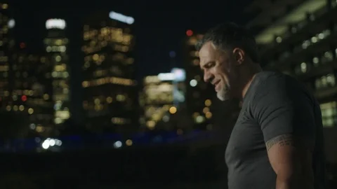 Man 50's working out on night streets in Downtown Los Angeles Video stock 103717913