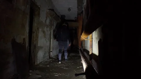 Man in abandoned destructed long corridor Stock Footage