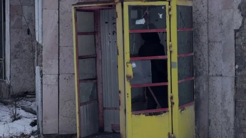 Man in abandoned telephone booth Stock Footage 70890650