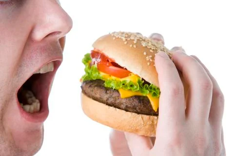 Man about to bite into a cheeseburger Stock Photos