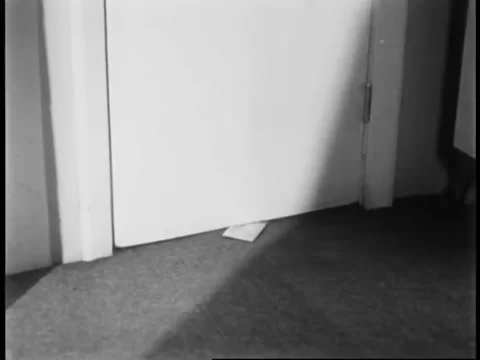 Man about to pick up envelope under door Stock Footage 260256122