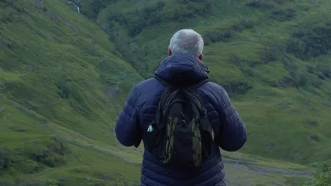 Man about to start a mountain ascent in the Scottish Highlands Stock Footage 219510023
