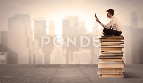 Man above the city sitting on books Stock Photos