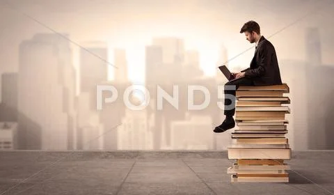 Man above the city sitting on books Stock Photos
