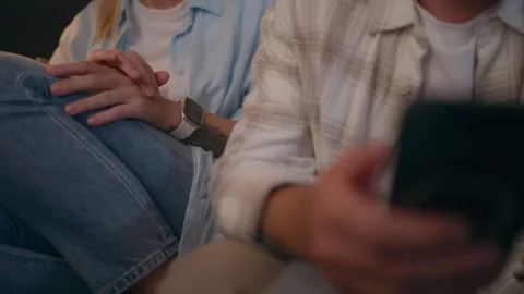 Man absorbed in smartphone while lonely woman sits beside him rubbing hands.. Stock Footage 342839140