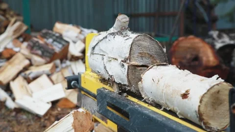 Man in action with an electric log splitter: An amazing combination of power and Stock Footage 275549354