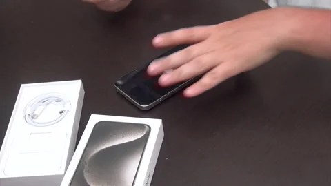 A man activates a purchased smartphone. Activation iPhone 15 pro max. Stock Footage 277481636