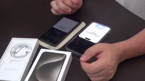 A man activates a purchased smartphone. Transferring information from an ol.. Stock Footage 277481579