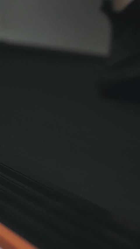 A man actively trains by running on a treadmill at home, maintaining his fitness Stock Footage 305570579