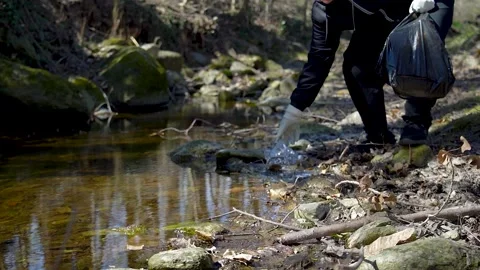 Man activist clean up plastic waste in a river Stock Footage 236902609