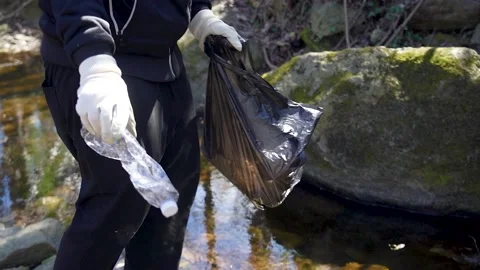 Man activist clean up plastic waste in a river Stock Footage 236903135