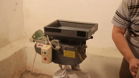 Man add malt to grind out of the bag to the mill. Grinding of malt for producing 動画素材 87898401