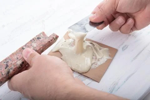 Man adding adhesive  a broken marble  with a spatula Stock Photos