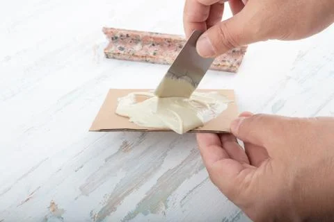 Man adding adhesive  a broken marble  with a spatula Stock Photos
