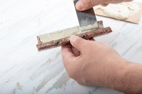 Man adding adhesive  a broken marble  with a spatula Stock Photos